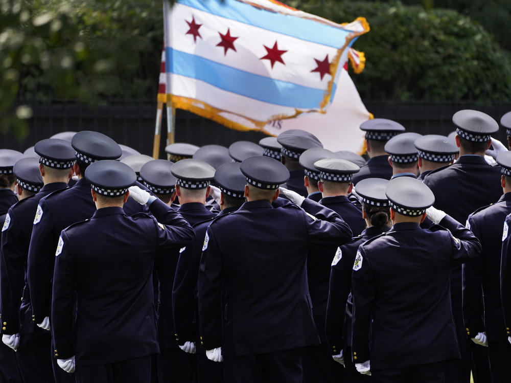 Chicago police officers salute the state flag on Aug. 18.