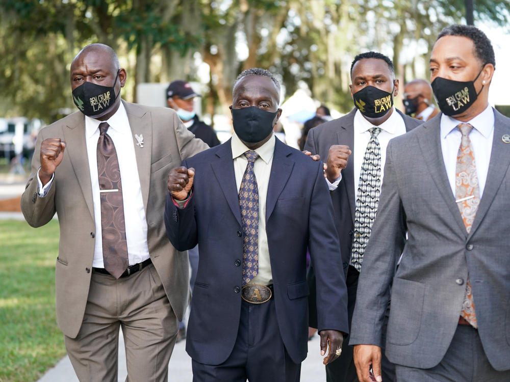Attorney Ben Crump, left, and Marcus Arbery Sr., the father of Ahmaud Arbery, second from left, arrive at the Glynn County Courthouse in Brunswick, Ga., as jury selection begins for the trial of the shooting death of Ahmaud Arbery on Monday.