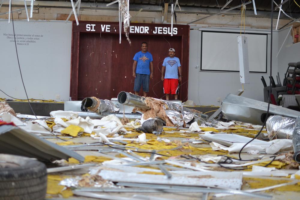 Pastor Pedro Rivera and congregation member Juan Ortega take stock of the damage at Iglesia Pentecostal Providencia Divina two days after Hurricane Ida hit Louisiana. It is a total loss.