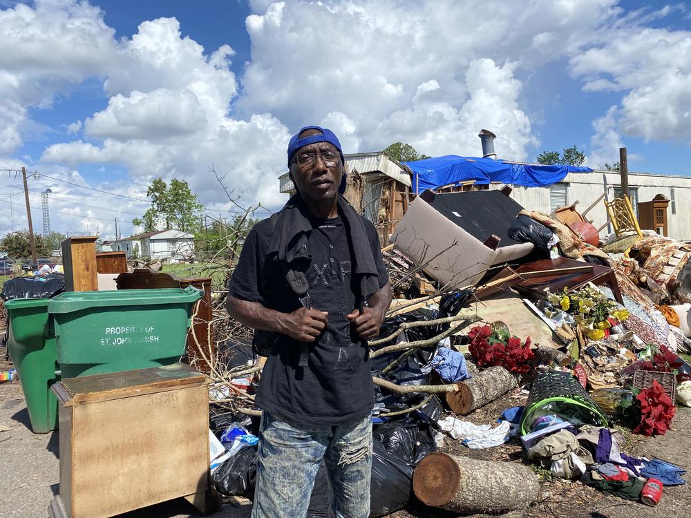 Donald Caesar, Jr., 49, stands in front of a pile of garbage. That's what's left of his family's home a month after Hurricane Ida ripped through LaPlace, La.