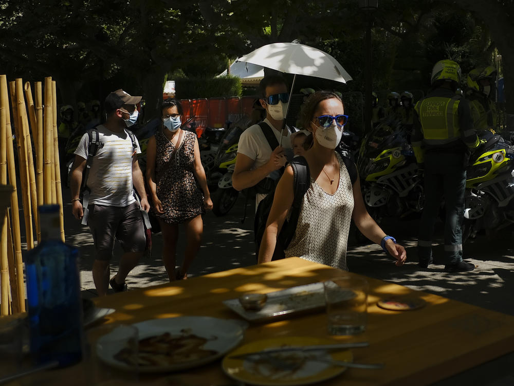 A man shelters a baby from the sun with an umbrella during a heatwave in Burgos, northern Spain, Saturday, Aug. 14, 2021. Cities in Europe saw recording-setting heat this summer, with some regions reaching 117.3°F.