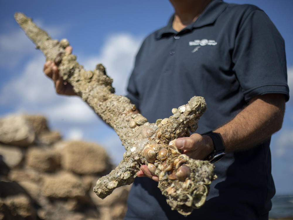 Jacob Sharvit, director of the Marine Archaeology Unit of the Israel Antiquities Authority, holds a sword that experts say dates back to the Crusaders in Cesarea, Israel, on Tuesday.