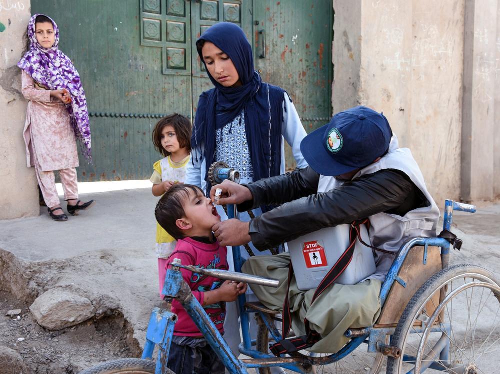 An Afghan health worker administers a polio vaccine to a child in Kandahar province in 2019. Since 2018, the Taliban has blocked polio vaccination campaigns in parts of the country it controls. Now they're reportedly changed their position.
