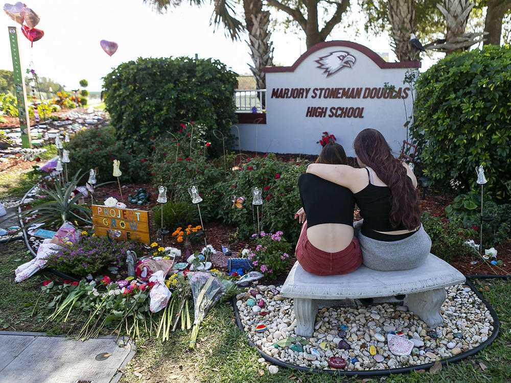 Mourners visit a makeshift memorial outside Marjory Stoneman Douglas High School in Parkland, Fla., on Feb. 14, 2020, during the two-year anniversary of the Parkland shooting that killed 17 people and injured another 17.