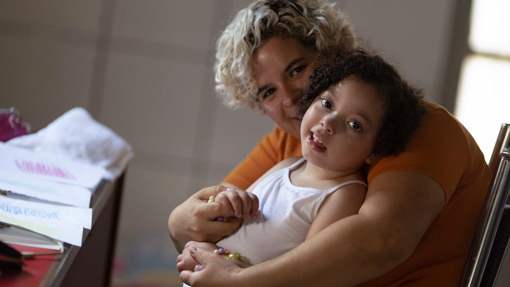 Rochelle dos Santos embraces her daughter, who was born with microcephaly in 2016 after dos Santos contracted Zika during her pregnancy in midwest Brazil.