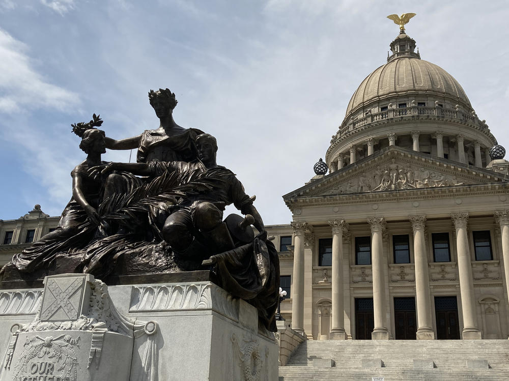 A monument to the women of the Confederacy stands in front of the Mississippi State Capitol.