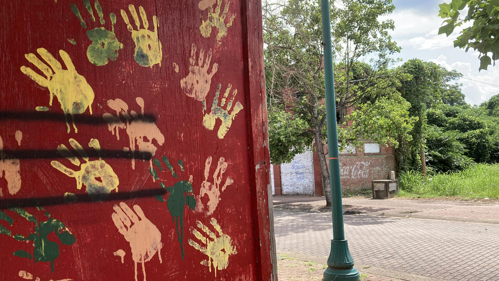 Handprints mark one of the boarded up buildings on Farish Street. Some lots on the street have been overtaken by weeds.