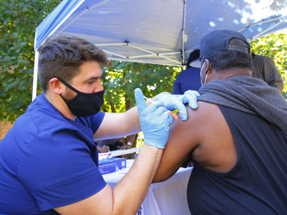 A health care worker administers a Pfizer-BioNTech COVID-19 vaccine Thursday at Life of Hope Center in New York City.