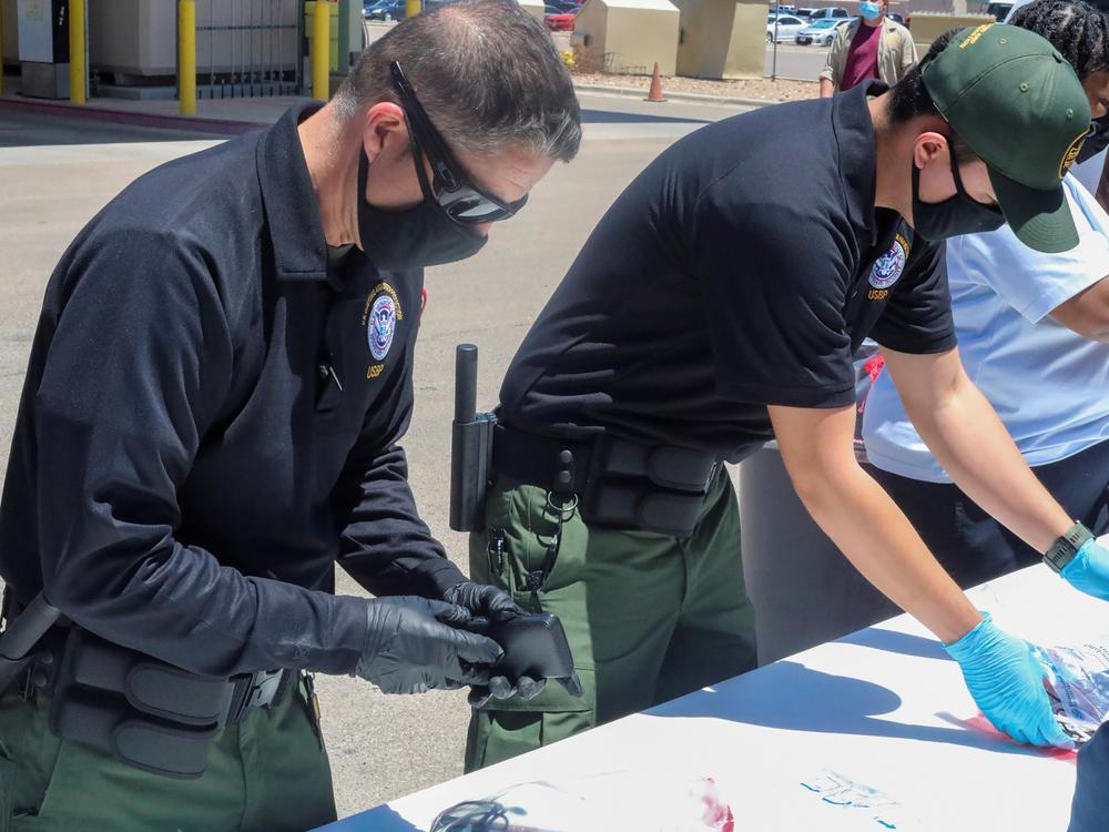 Officials help process and log personal items from migrants entering the Central Processing Center in El Paso, Texas, in this May 4 photo provided by the U.S. Border Patrol.