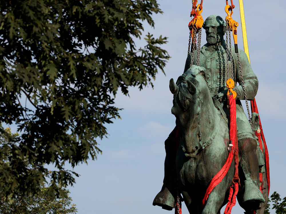 Workers remove a statue of Confederate Gen. Robert E. Lee from Market Street Park in Charlottesville, Va., in July. Initial plans to remove the statue four years ago sparked the infamous 