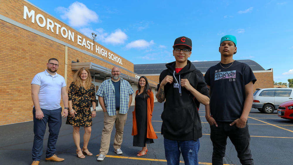 Cicero, Ill— Teachers Mark Sujak, Sarah Lorraine, Jeremy Robinson and Sophia Faridi pose with students and podcast finalists Julian Fausto and Eric Guadarrama for portraits in front of Morton East High School, Friday July 30, 2021. Photo: Olivia Obineme for NPR.