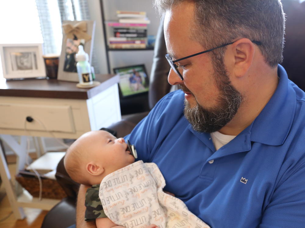 Scott Baisley holds his son Sullivan, who was delivered shortly before his mother died of COVID-19.