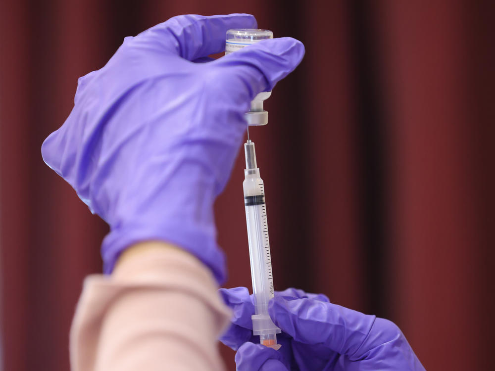 A nurse draw a Moderna COVID-19 vaccine dose from a vial at the Cameron Grove Community Center in Bowie, Md., in late March. Moderna says study data supports use of a half-dose of the vaccine in children 6 to 11.