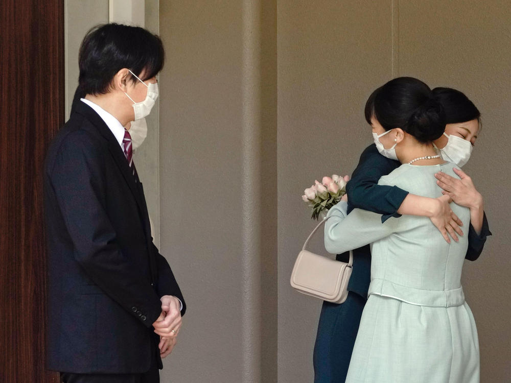 Japan's Princess Mako, right, hugs her sister Princess Kako, watched by her parents Crown Prince Akishino and Crown Princess Kiko, before leaving her home in Tokyo. Mako and  commoner Kei Komuro tied the knot Tuesday without wedding celebration in a marriage that has split public opinion over her would-be mother-in-law's financial controversy.