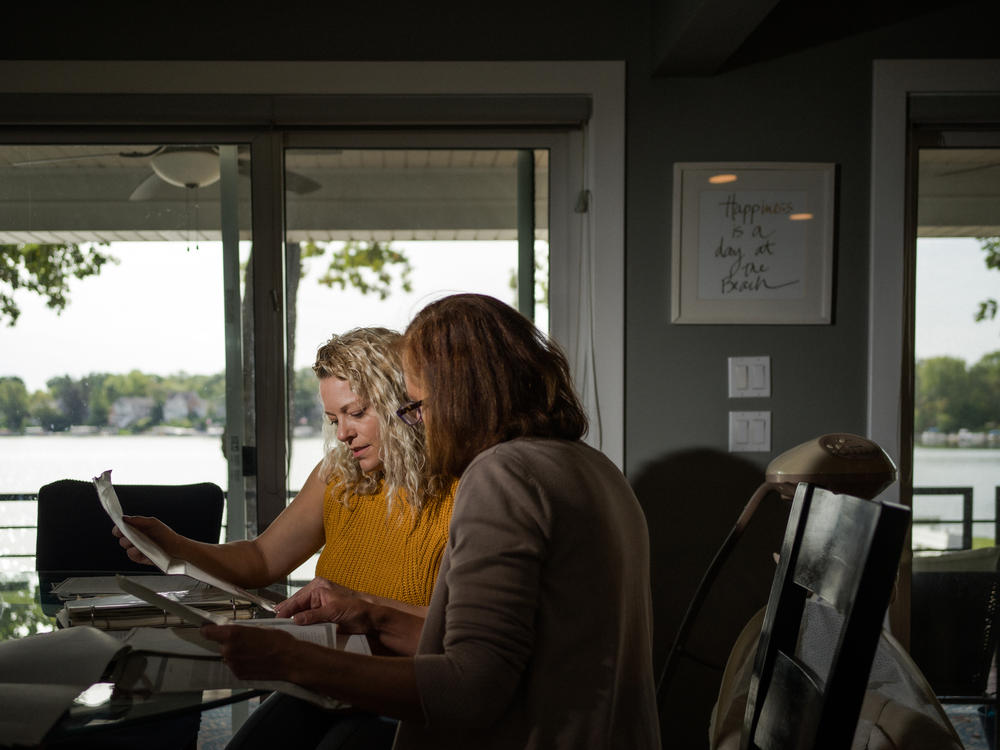 Nicole Sullivan (left) and her neighbor Catherine Shannon look over property documents in Mundelein. Together, they convinced a state lawmaker to sponsor a bill to remove the racial covenants from the record.