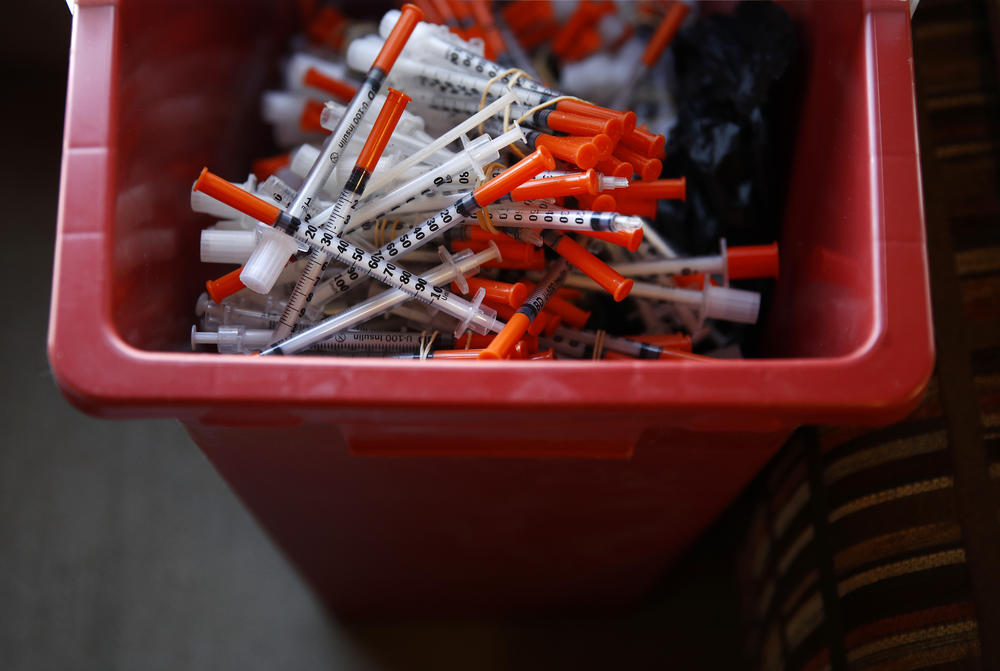 Used needles sit in a container inside the Baltimore City Health Department's Needle Exchange Team van in Baltimore in 2018. The Biden administration's plan also embraces expansion of needle exchange programs, which have been shown to reduce the spread of diseases such as HIV/AIDS and hepatitis among people with addiction.