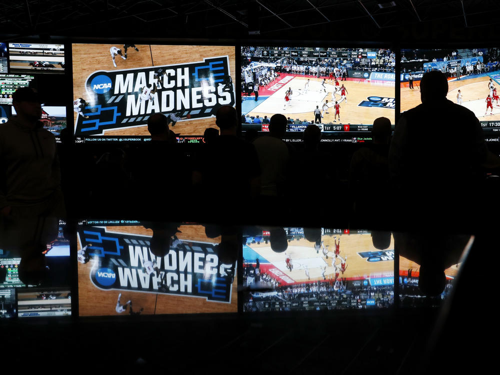 People watch coverage of the first round of the NCAA college basketball tournament at the Westgate Superbook sports book on March 15, 2018, in Las Vegas.