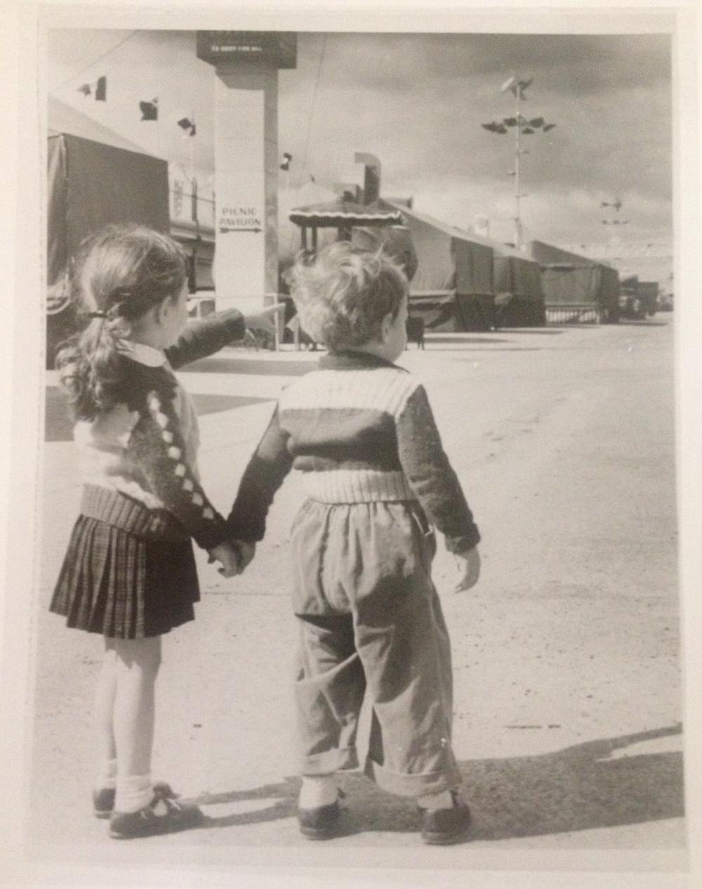 Bobby and Fritzi Huber hold hands at fairgrounds, circa 1950s.