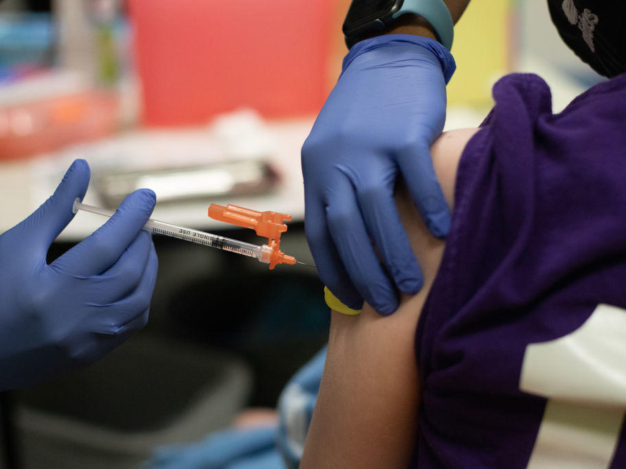 A health care worker administers a dose of the Pfizer-BioNTech COVID-19 vaccine to a child at a pediatrician's office in Bingham Farms, Michigan. Federal agencies are considering whether to start giving the vaccine to children ages 5 to 11 in the near future.