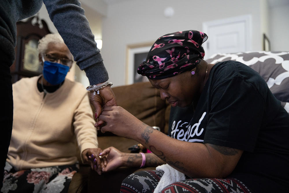 Nunny Reece, 42, grasps the hands of her aunt, Tina Foster (left), and a group of her 