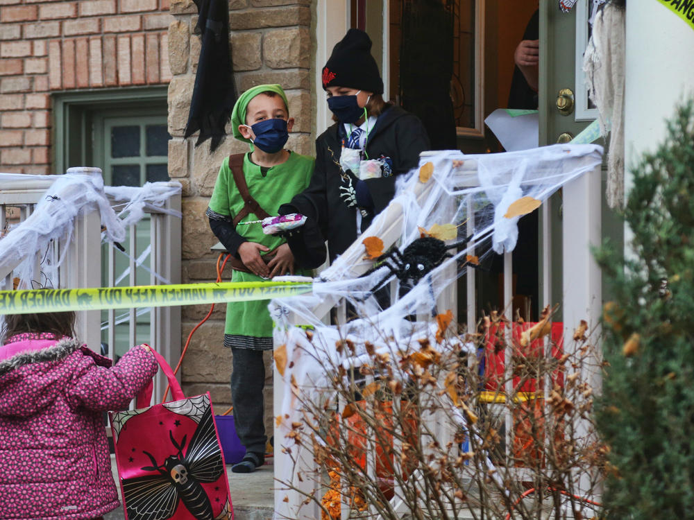 Children wear face masks to protect them during the pandemic while trick-or-treating on Halloween night in Thornhill, Ontario, Canada, on Oct. 31, 2020.