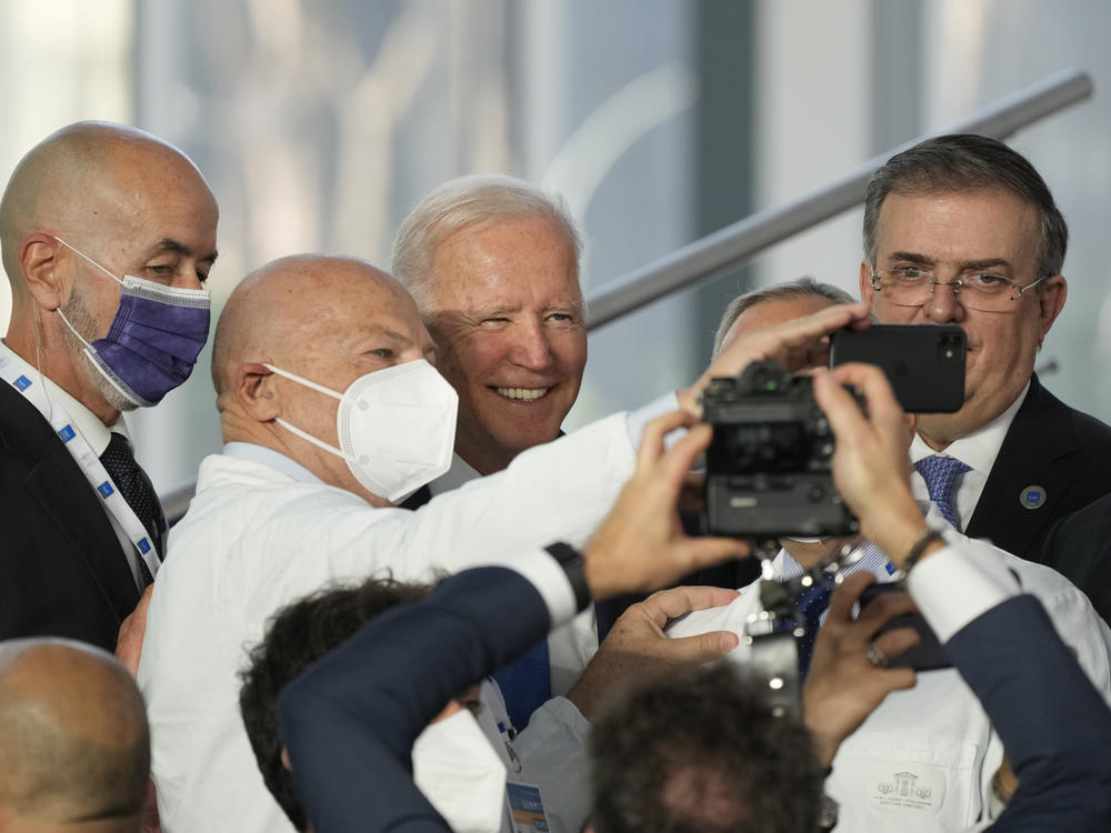President Biden poses for a selfie with first responders who joined world leaders Saturday for the traditional family photo at the G-20 summit in Rome.