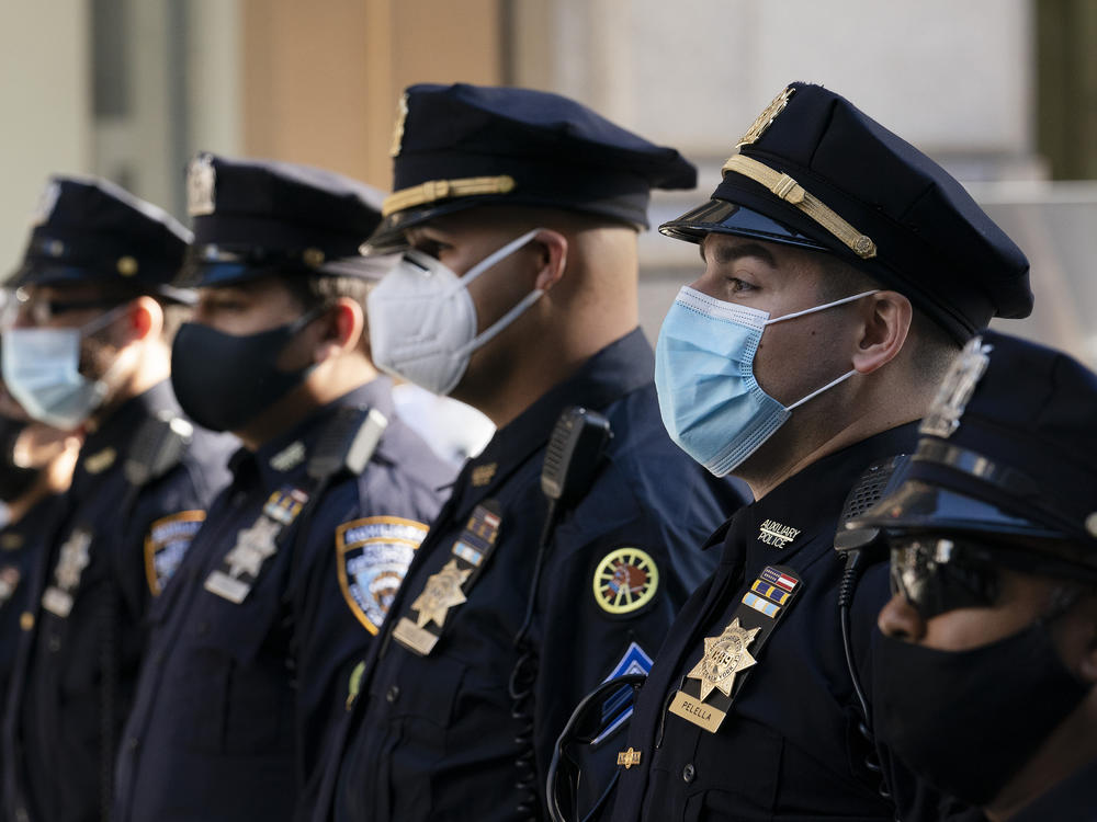 New York Police Department officers in masks stand during a service at St. Patrick's Cathedral in New York, last October.