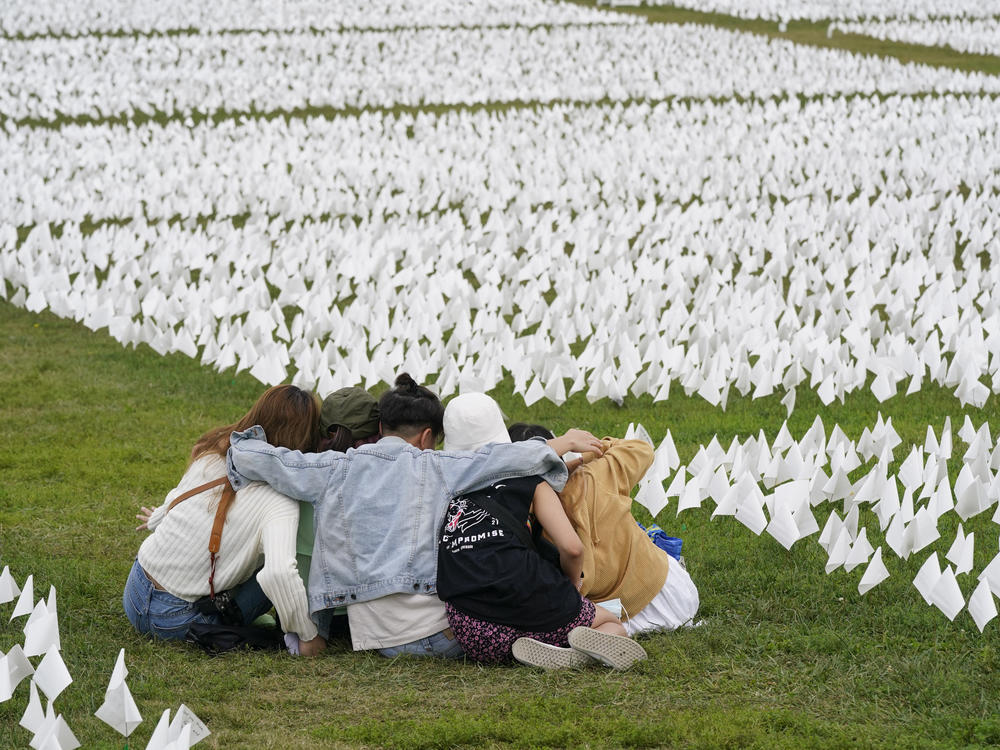 In September, visitors sit amid white flags that were part of artist Suzanne Brennan Firstenberg's 