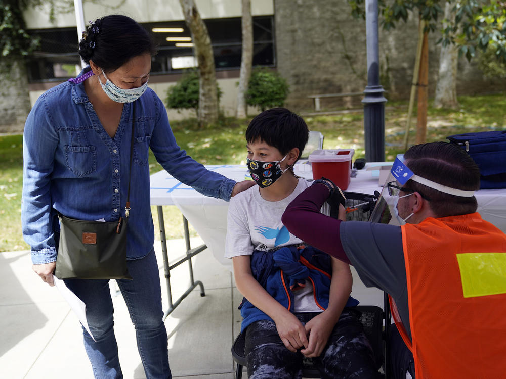 Colin Sweeney, 12, got a shot of the Pfizer COVID-19 vaccine as his mother, Nicole, stands by in Pasadena, Calif., in May. As of this week, kids aged 5 to 11 can also get vaccinated against COVID-19.