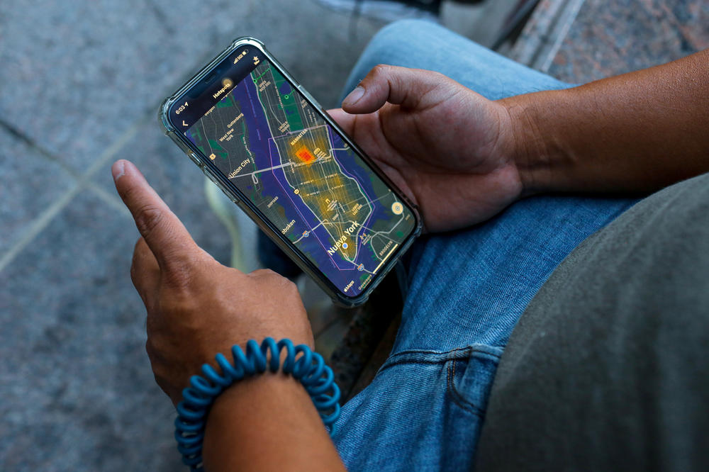 Gustavo Ajche tracks an order on his phone. He delivers food on an e-bike, weaving in and out of traffic sometimes at 30 mph or faster.