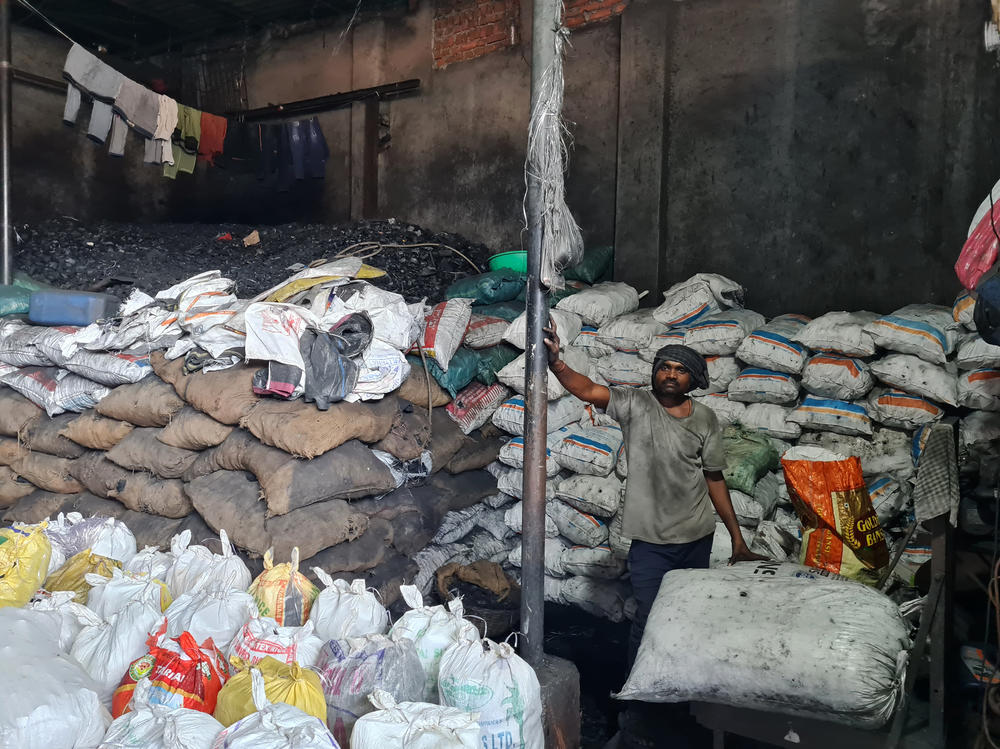 Workers shovel heaps of coal into sacks inside the Choudhary Coal Depot in Mumbai. Its manager, Abdul Moeed Chaudhary, is the third generation of his family to run the facility. But he, like India, is looking to diversify away from coal. Chaudhary recently got a master's degree in renewables.