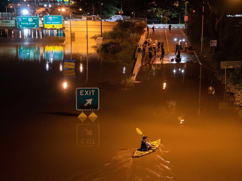 A kayaker paddles down an interstate in Pennsylvania after flooding from Hurricane Ida earlier this year. Several dozen people died, some in cars and basement apartments, during extreme flash flooding.