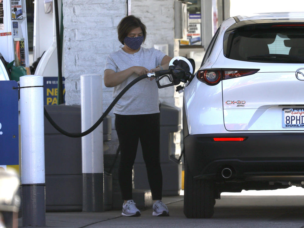 A customer pumps gas into her car at a Shell station on Oct. 12 in San Francisco. Prices for all kinds of things, including gas and food, have surged during the pandemic.