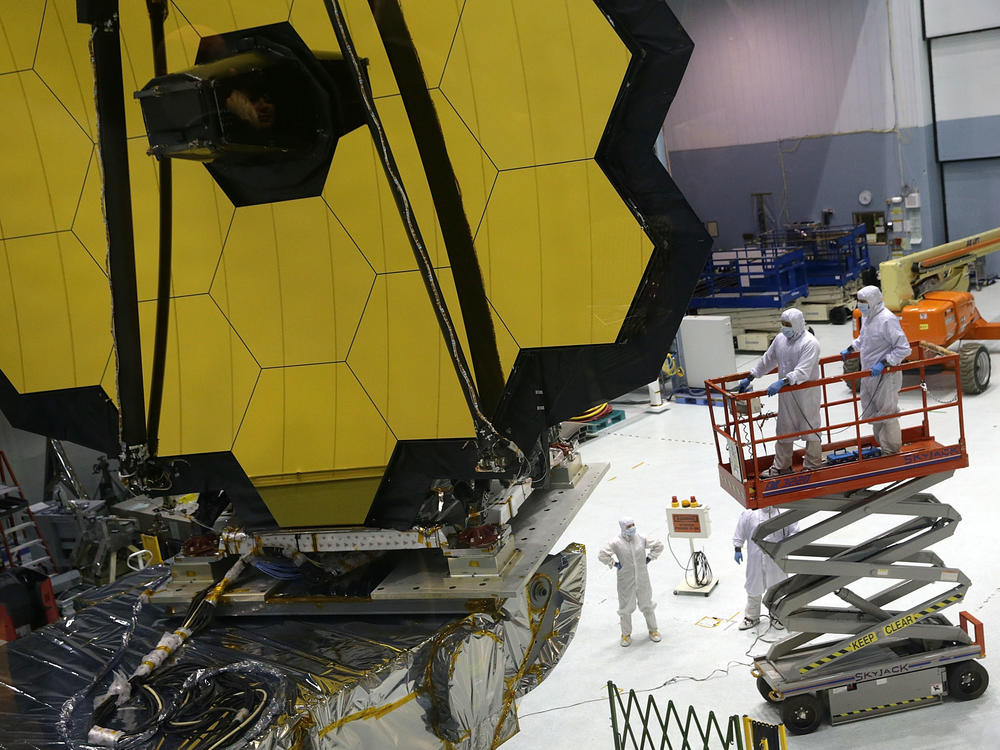 Technicians work on NASA's James Webb Space Telescope, which will launch in December. Astronomers say the next big telescope should be designed to search signs of life on planets that orbit distant stars.