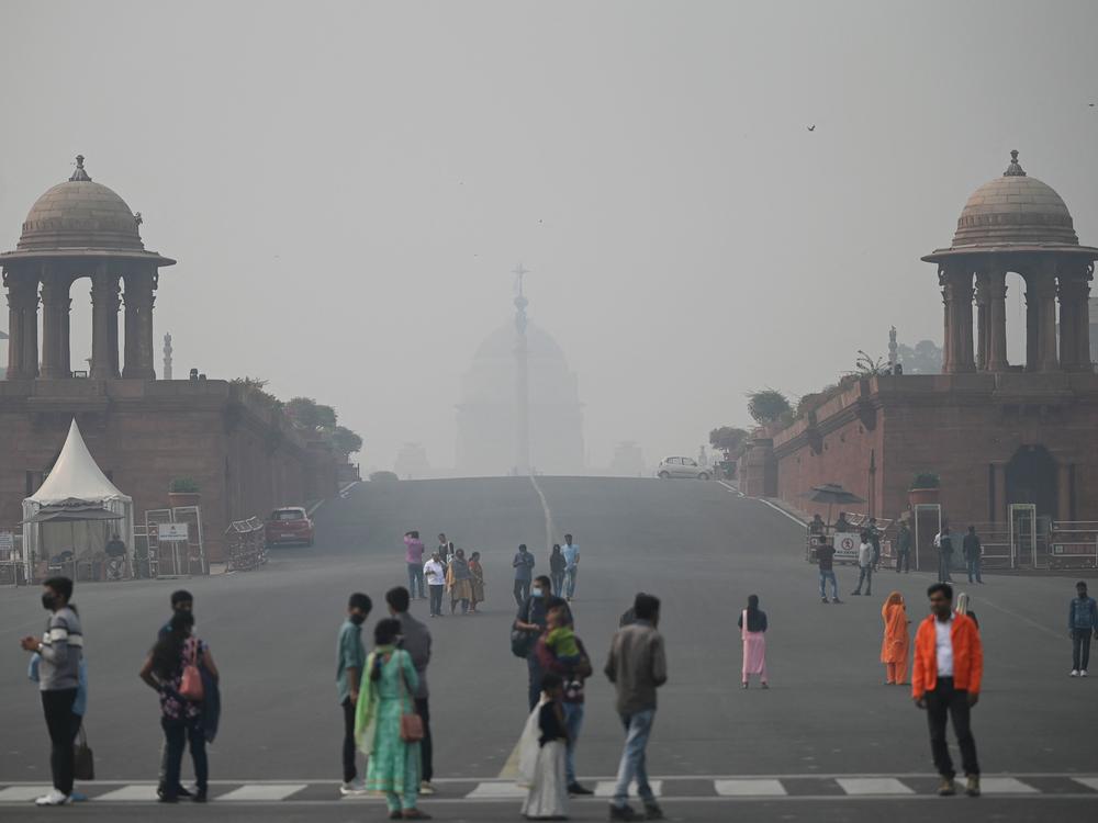 Visitors walk along the Raisina Hills at Rajpath amid smoggy conditions in New Delhi on Thursday.