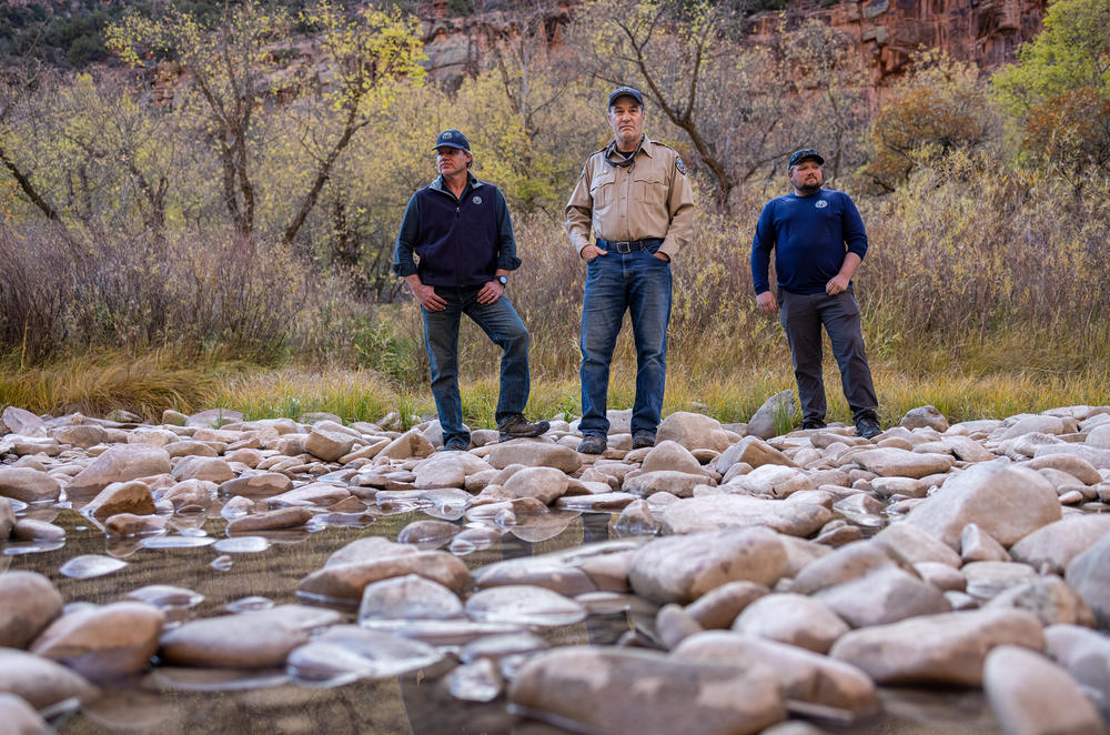 Jim White, center, a biologist with Colorado Parks and Wildlife, stands by the dried up riverbeds at the Dolores River Canyon next to Ryan Unterreiner and John Livingston who are also with the organization.