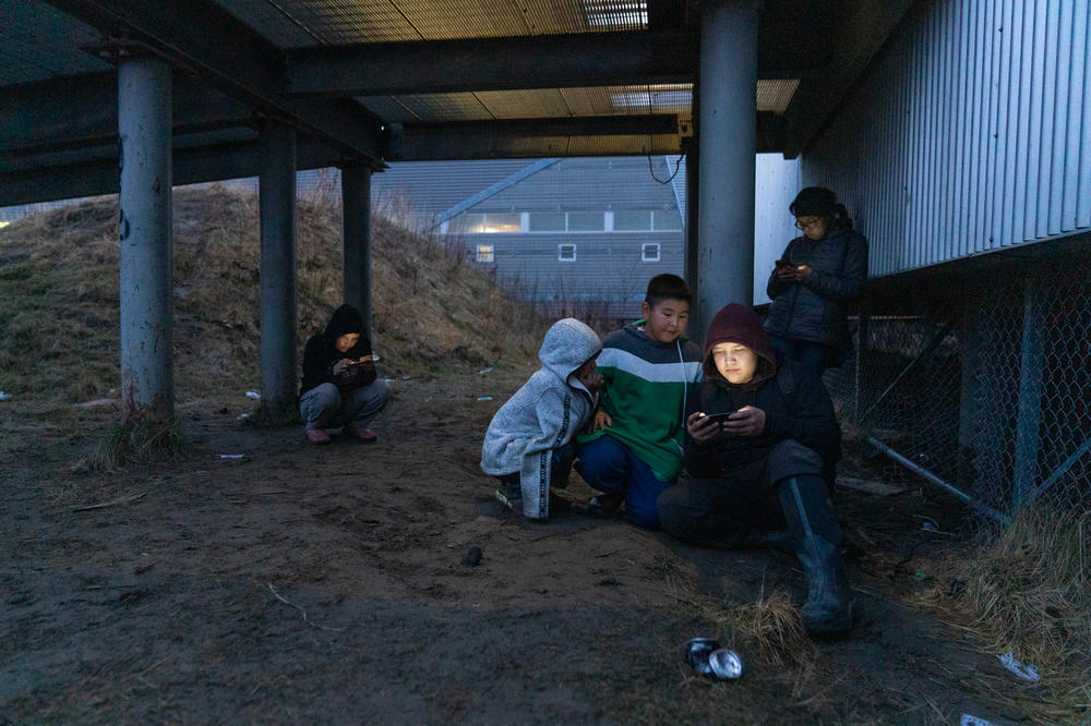 Kids hang out near the school in Akiak, Alaska to access wireless internet through their phones.