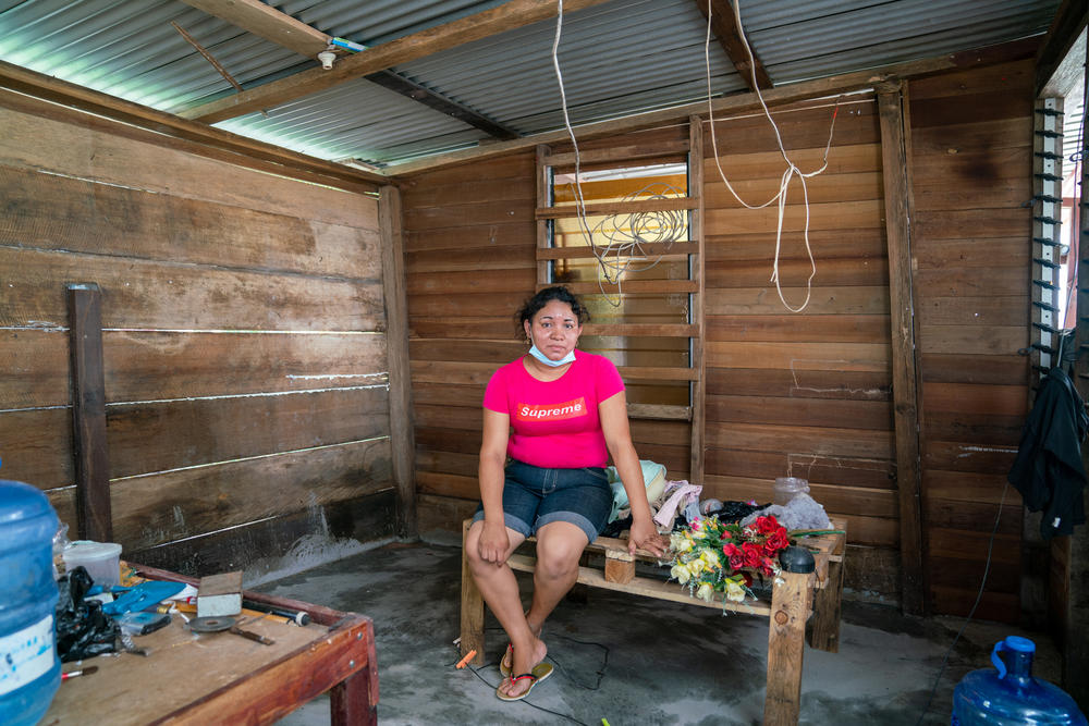 Polly Persaud, Chandroutie's daughter-in-law, lived for two weeks in knee-high water before moving with her children into a shelter. Here, she sits on one of the many structures she fashioned to hold things above the water. She and her husband would take turns watching the floodwaters, never sleeping at the same time, to make sure they didn't rise more.