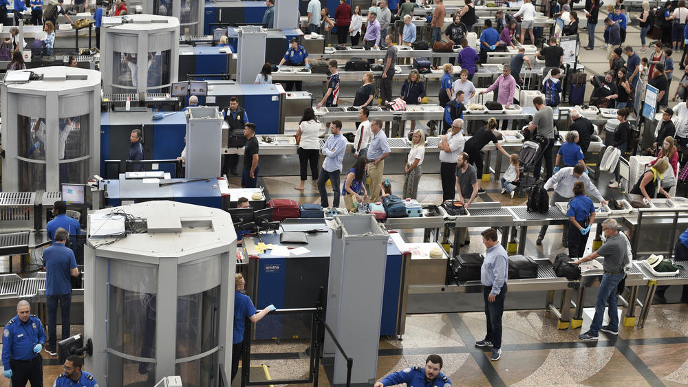 Airplane passengers line up for TSA security screenings at Denver International Airport.