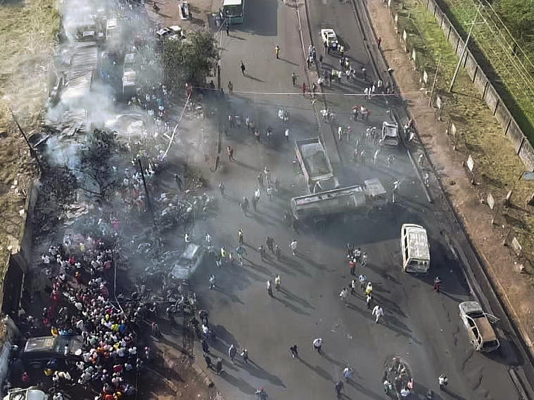 In this photograph issued Saturday by Sierra Leone's National Disaster Management Agency, people gather around the charred oil tanker that exploded after being struck by a truck in the Wellington suburb of Sierra Leone's capital Freetown on Saturday.
