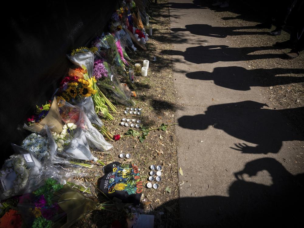 Visitors cast shadows at a memorial to the victims of the Astroworld concert in Houston on Sunday, Nov. 7, 2021.