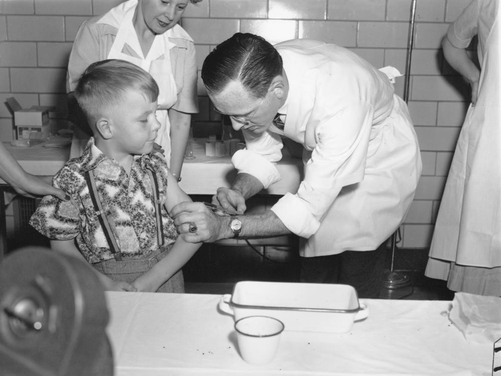 Dr. Richard Mulvaney of Mclean, Va., injects the new polio vaccine into the arm of 6-year-old Randall Kerr, the first of some 100 children to be inoculated on April 26, 1954.