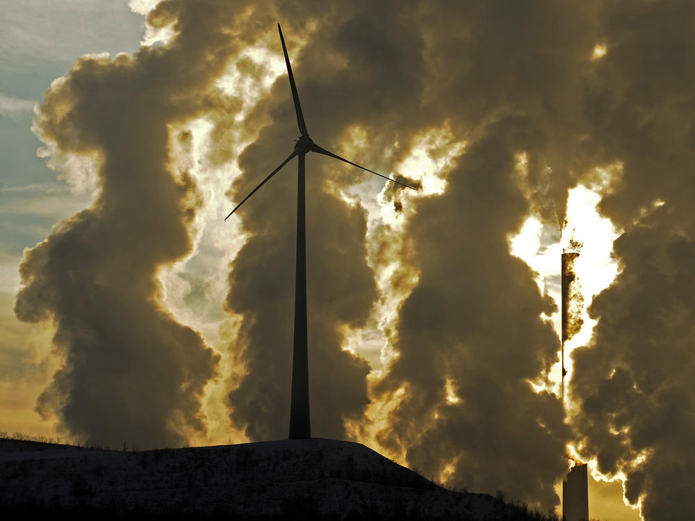 A wind turbine in front of a steaming coal power plant in Gelsenkirchen, Germany in 2010. New reports find countries' latest promises to cut climate emissions are still not enough to avoid the worst impacts from warming.