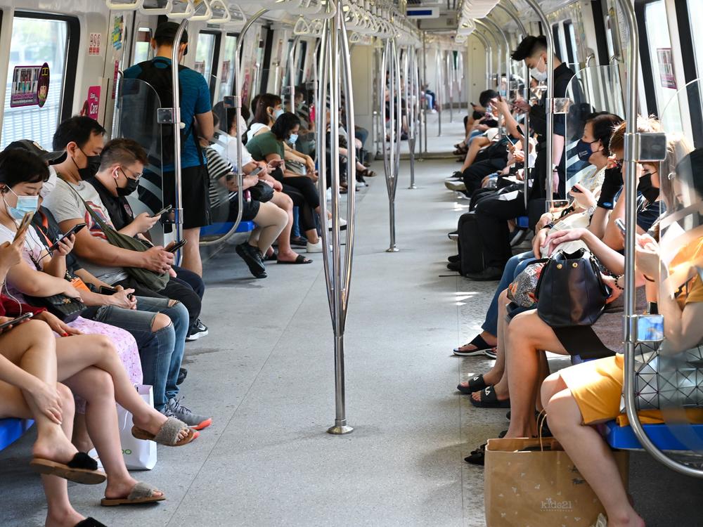 People in Singapore mask up to take a mass rapid transit train on Friday. Singapore has one of the highest vaccination rates in the world. As of Sunday, 85% of its population was fully vaccinated.