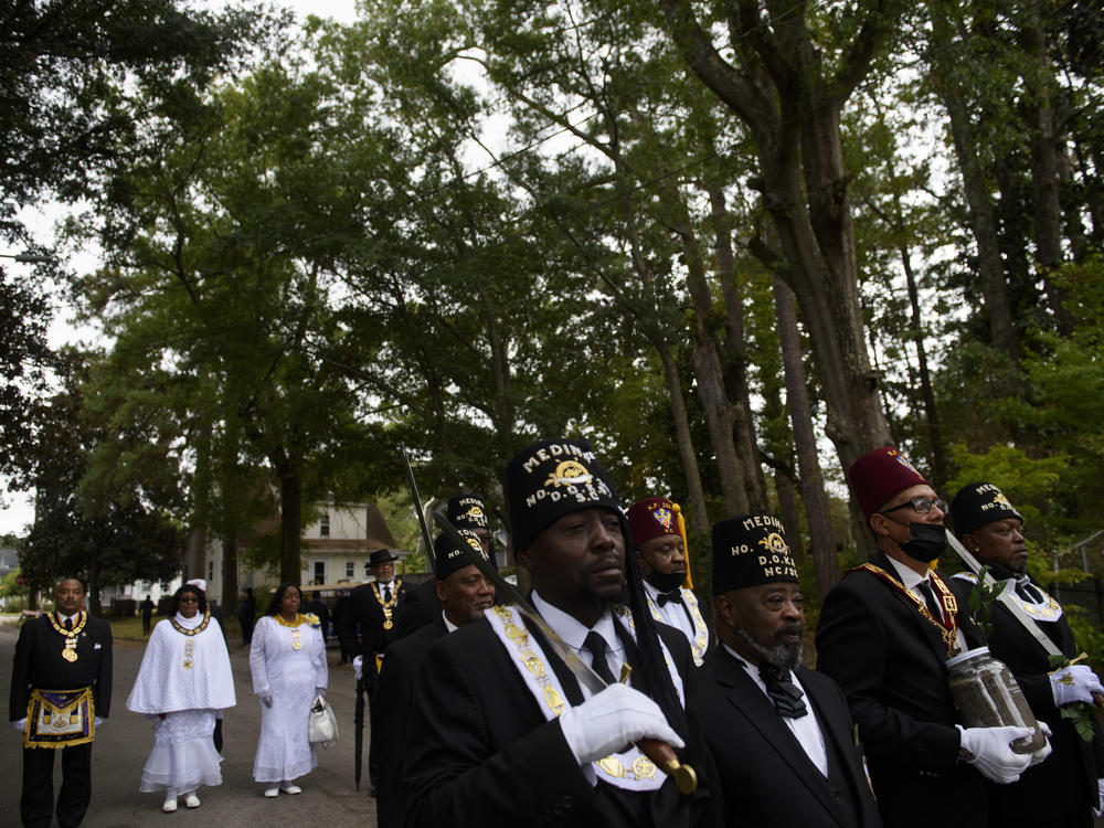 Members of the Grand Lodge of South Carolina carry soil collected in honor of Joshua Halsey to his gravesite at the Pine Forest Cemetery in Wilmington, N.C., on Nov. 6. Great-granddaughters of Halsey attended the service, where the Rev. William Barber II eulogized Halsey.
