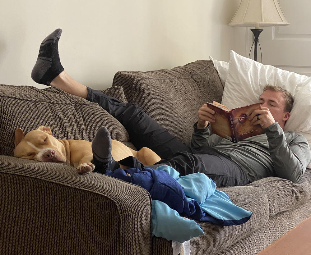 Nick recovers at home with his dog Teddy in September 2020. Unable to do much on his feet, Nick made a point to read as much as possible.