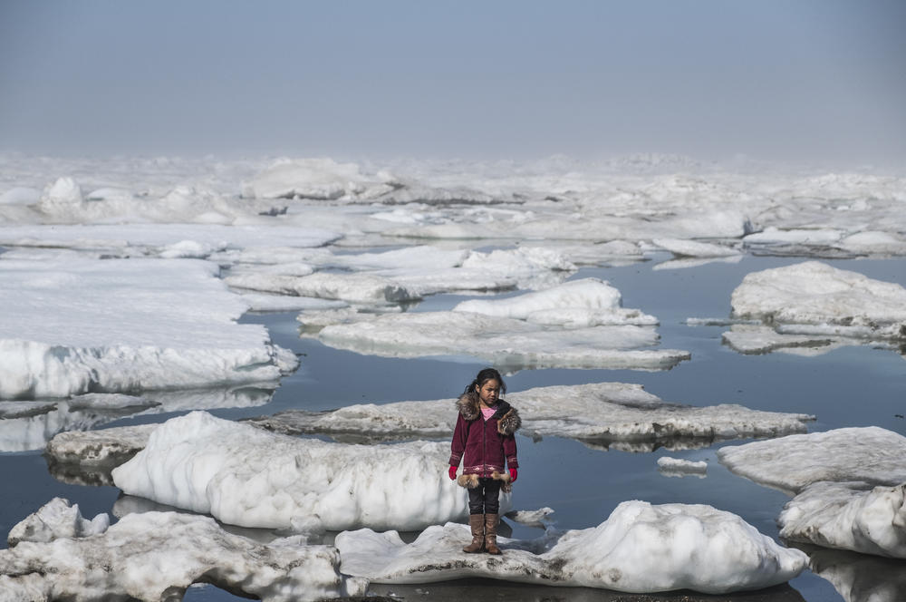 An Inupiat girl named Amaia, 11, stands on an ice floe on a shore of the Arctic Ocean in Barrow, Alaska. The anomalous melting of the Arctic ice is one of the many effects of global warming that has a serious impact on the life of humans and wildlife.