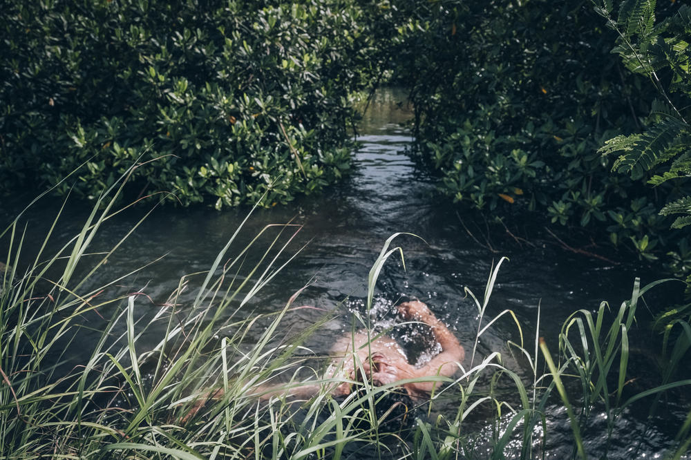 Simanu, 25, enjoying water in Moata'a Mangrove Reserve in Apia, on Samoa's Upolu island. The Samoan government supports many local communities through replanting mangroves that protect people and their livelihoods from rising sea level and coastal erosion.