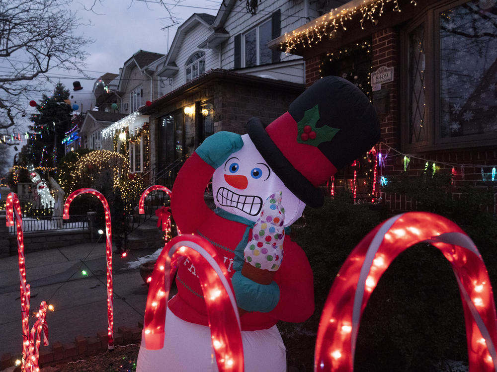 An inflatable snowman and candy canes are part of the decorations that adorn houses in Brooklyn's Dyker Heights neighborhood on Dec. 22, 2020 in New York. A shopping surge by households this year has snarled up global supply chains, and now the race is on to get products on shelves in time for Christmas.