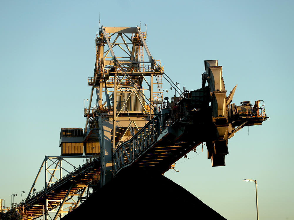 A stacker-reclaimer next to a stockpile of coal at the Newcastle Coal Terminal in Newcastle, New South Wales. Australia is a major coal producer. A new draft agreement at the climate summit in Scotland calls for ending coal power.